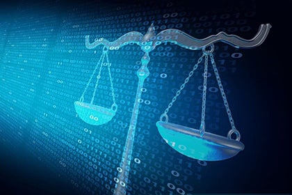 Scales of justice overlaying a computer dislay of binary code