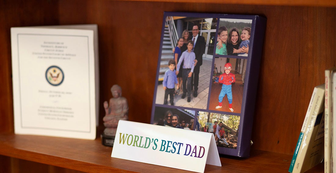Items on a shelf with the focuse on a "World's Best Dad" card and a photo of Michael Waterstone and his family