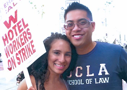 Two UCLA Law students, one of whom is holding a sign stating that there is a W Hotel workers' strike