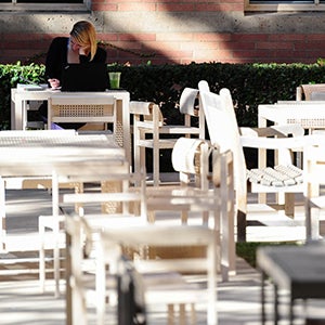 A UCLA Law student seated at a courtyard table