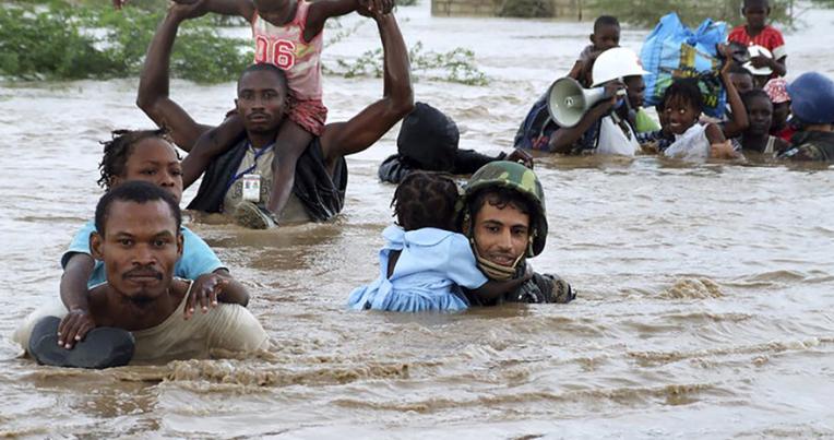 People walking through rising floodwaters