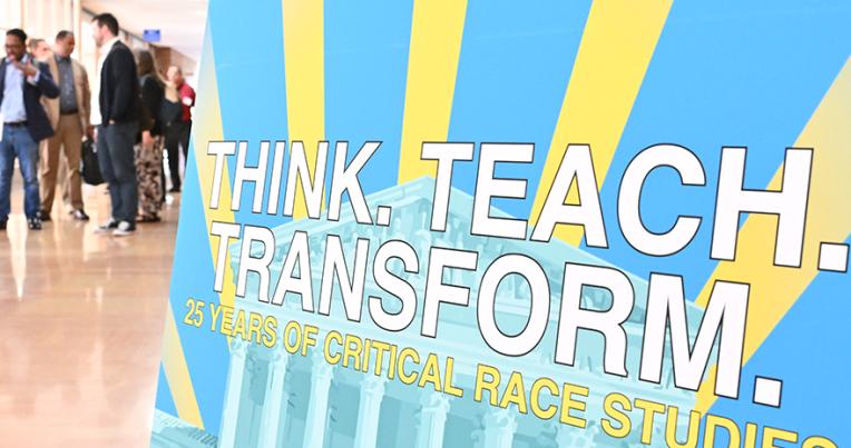 Poster for the CRS symposium with attendees in the background