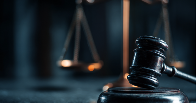 A judge's gavel with the scales of justice in the background