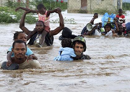 People walking through rising floodwaters