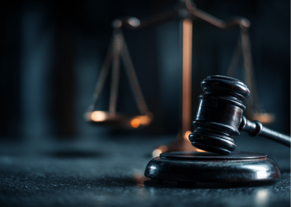 A judge's gavel with the scales of justice in the background